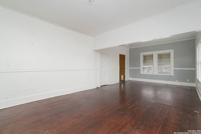 empty room with crown molding, baseboards, and hardwood / wood-style floors