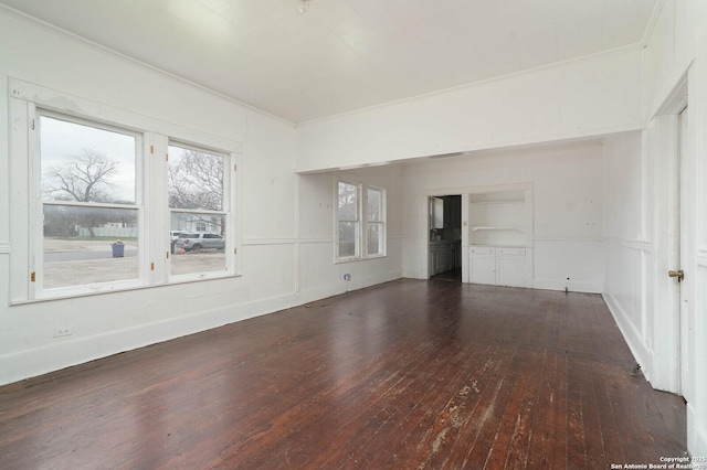 spare room with a decorative wall, ornamental molding, and hardwood / wood-style flooring