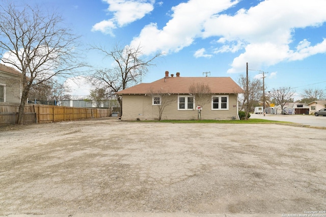 rear view of property featuring fence