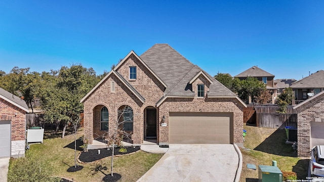 view of front facade with brick siding, a shingled roof, concrete driveway, a front yard, and an attached garage