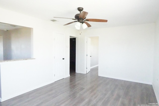 unfurnished room with visible vents, baseboards, wood finished floors, and a ceiling fan