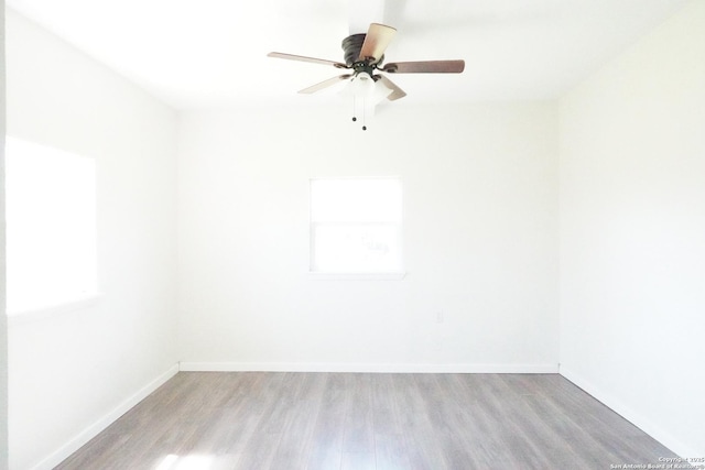 spare room with wood finished floors, baseboards, and ceiling fan