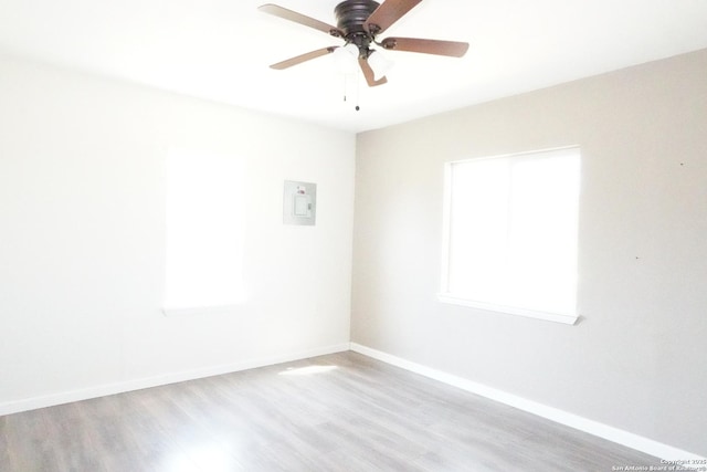 spare room featuring baseboards, wood finished floors, and a ceiling fan