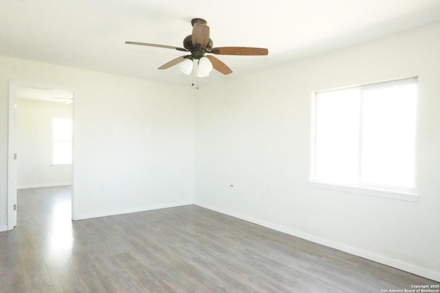 unfurnished room with wood finished floors, baseboards, and ceiling fan