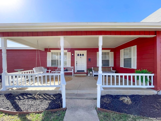 view of exterior entry with a porch