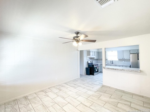 unfurnished living room with a sink, visible vents, a textured ceiling, and ceiling fan