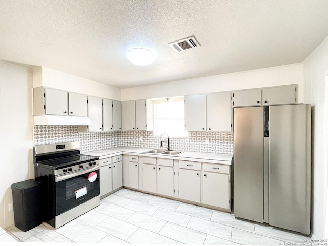 kitchen featuring visible vents, under cabinet range hood, light countertops, stainless steel appliances, and a sink