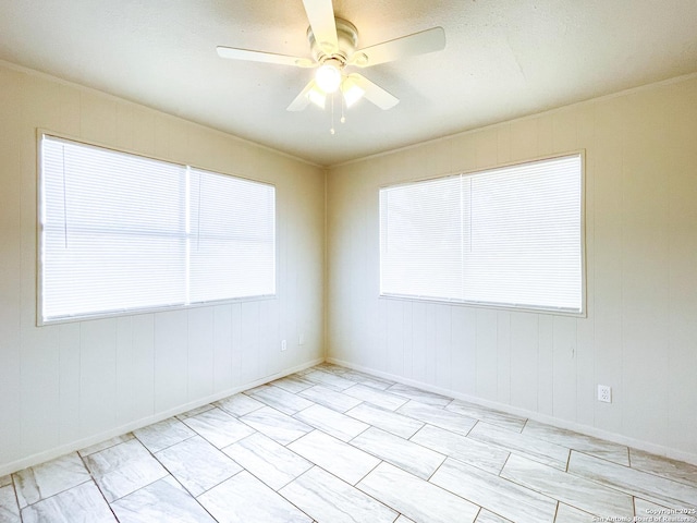 spare room featuring plenty of natural light and ceiling fan