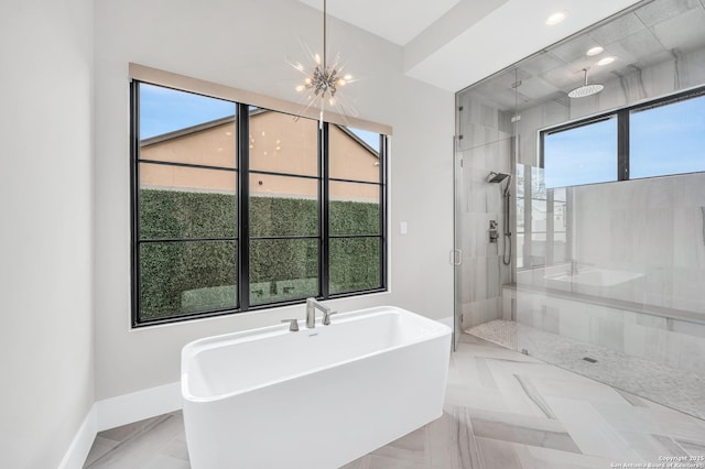 full bathroom featuring a stall shower, recessed lighting, an inviting chandelier, baseboards, and a soaking tub