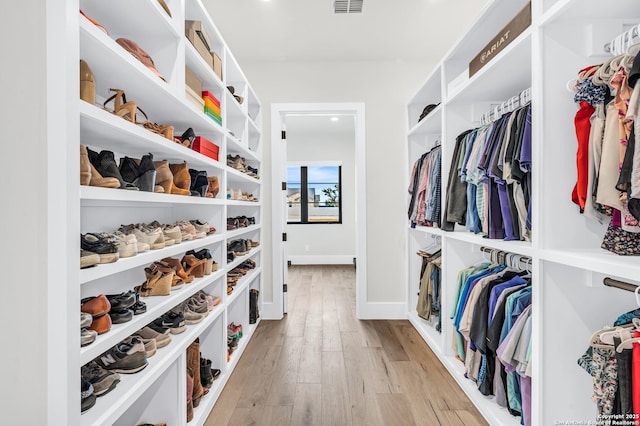 walk in closet featuring light wood-type flooring and visible vents