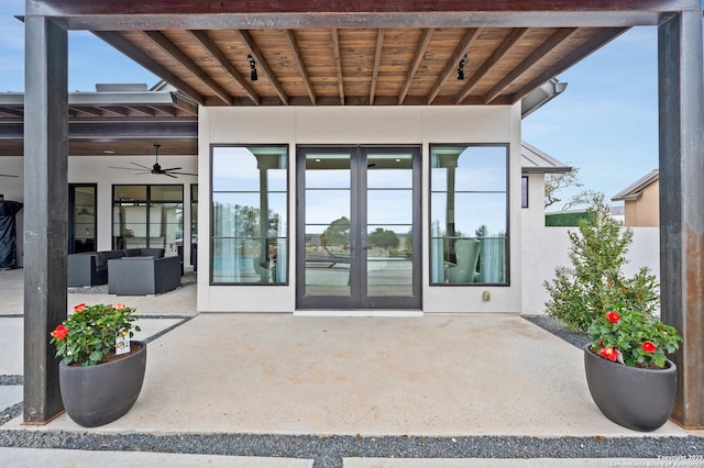 entrance to property featuring a standing seam roof, a patio area, french doors, and stucco siding