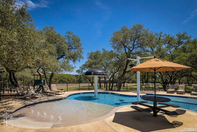 community pool featuring a patio, fence, and playground community