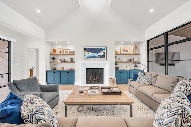 living room with recessed lighting, light wood-type flooring, high vaulted ceiling, and a fireplace