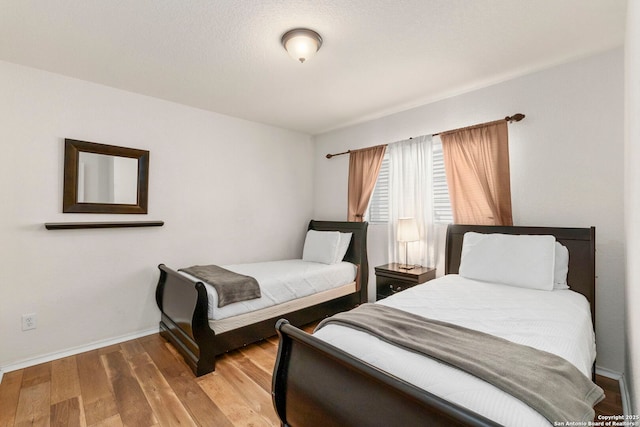 bedroom with wood finished floors and baseboards