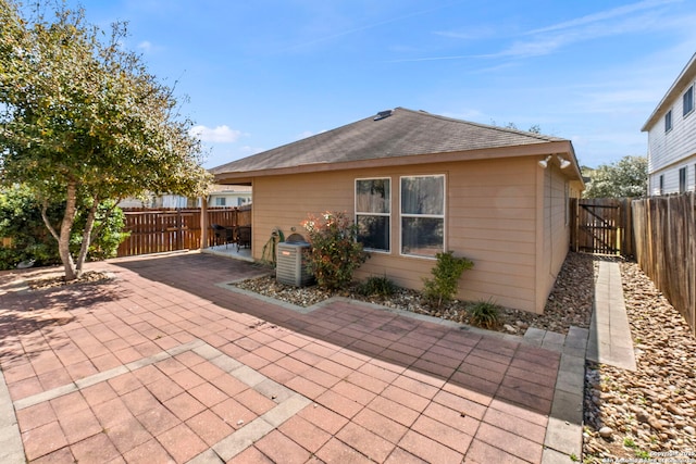 back of house featuring a patio area, a fenced backyard, and roof with shingles