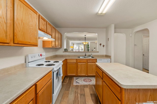 kitchen featuring dark wood-style flooring, a sink, light countertops, under cabinet range hood, and white electric range