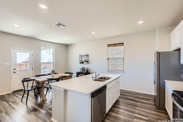 kitchen with a sink, stainless steel appliances, dark wood-type flooring, and visible vents