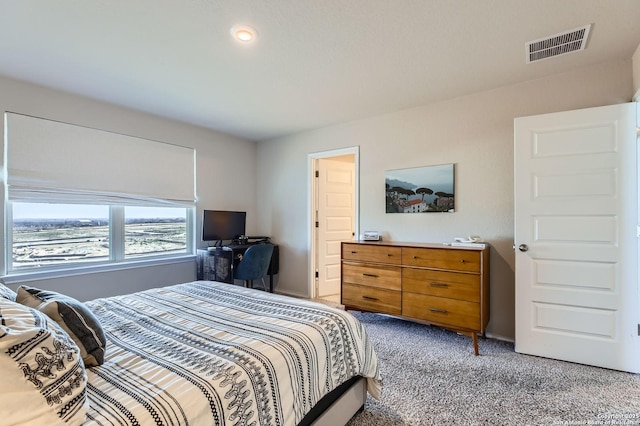 bedroom featuring visible vents and light colored carpet