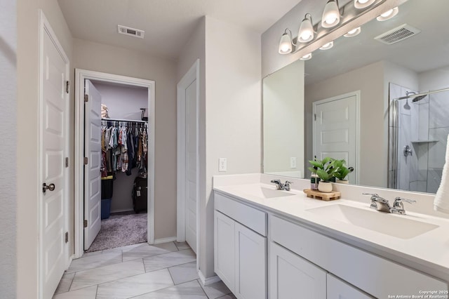 bathroom with double vanity, a stall shower, visible vents, and a sink