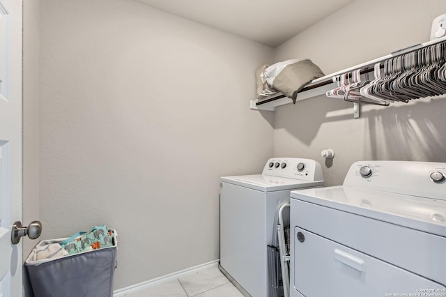 laundry room featuring washing machine and clothes dryer, laundry area, marble finish floor, and baseboards