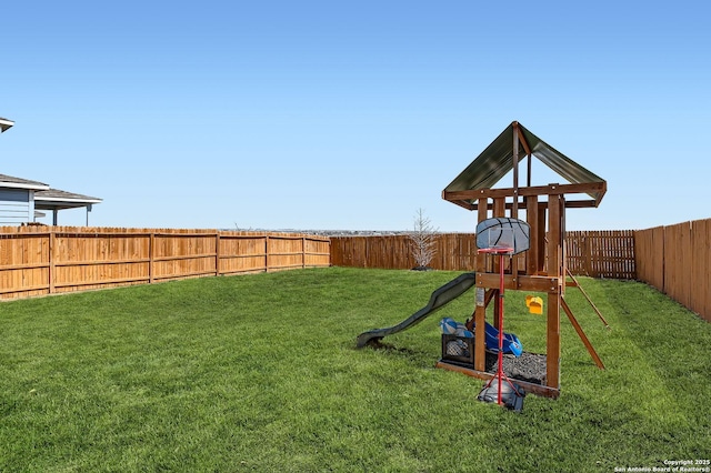 view of play area featuring a lawn and a fenced backyard