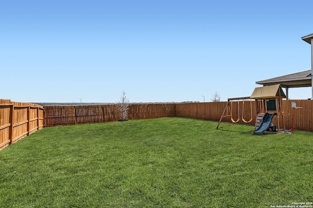 view of yard featuring a playground and a fenced backyard