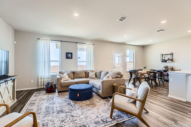 living room with dark wood finished floors, recessed lighting, and visible vents