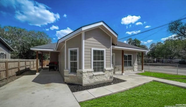 exterior space with stone siding and fence