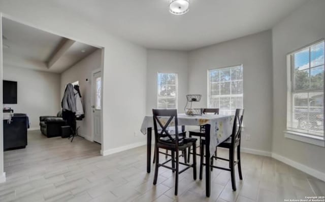 dining space with a wealth of natural light, baseboards, and light wood-style flooring