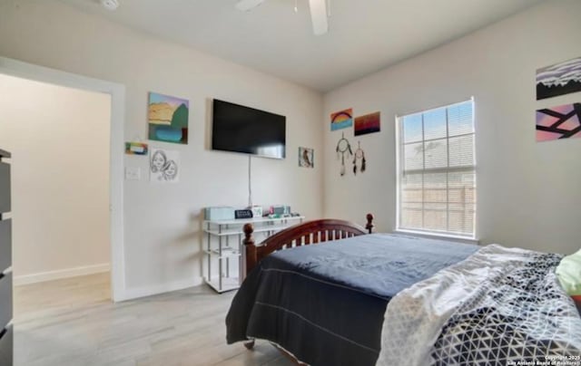 bedroom with ceiling fan, baseboards, and wood finished floors