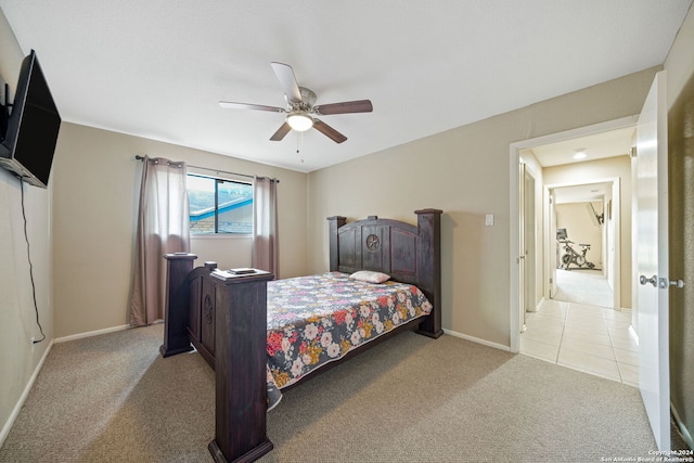 carpeted bedroom with tile patterned floors, baseboards, and ceiling fan