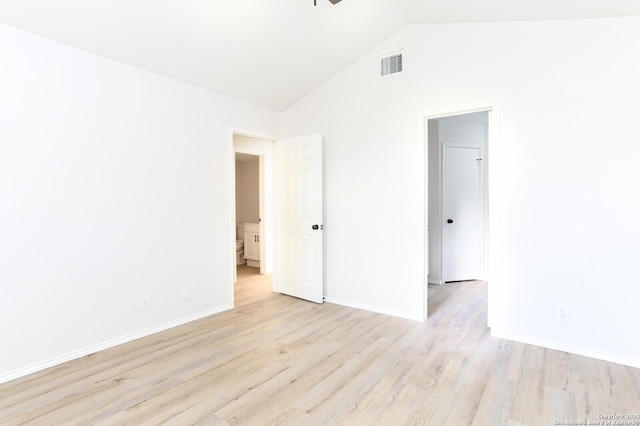 unfurnished room with visible vents, lofted ceiling, baseboards, and light wood-style flooring