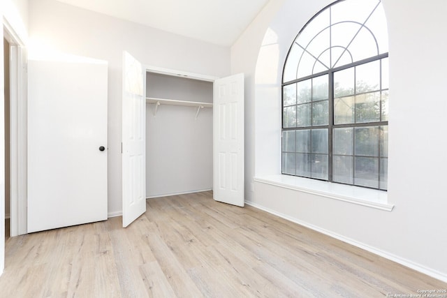 unfurnished bedroom with a closet, baseboards, and wood finished floors