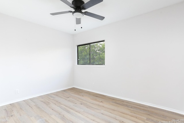 spare room featuring light wood-type flooring, baseboards, and ceiling fan