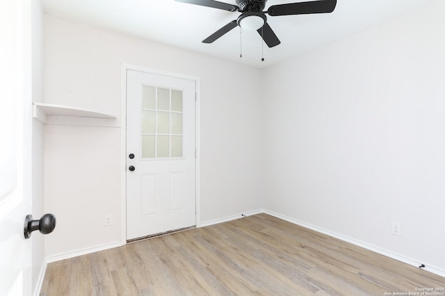 spare room with baseboards, light wood-type flooring, and ceiling fan