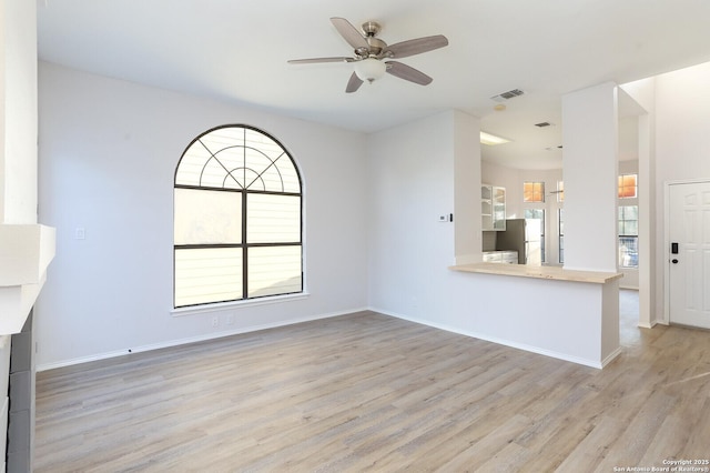 unfurnished living room with visible vents, baseboards, and wood finished floors