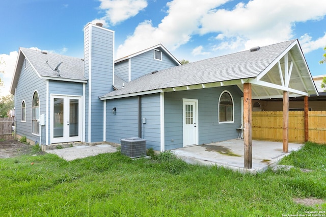 back of property with a patio area, french doors, a shingled roof, and fence