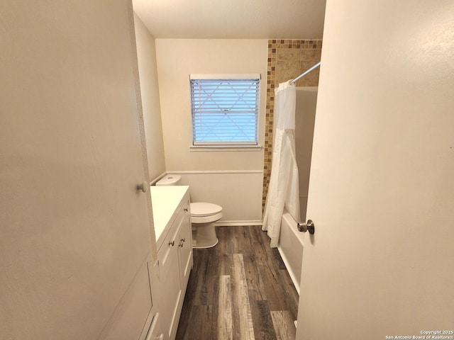 full bath featuring toilet, shower / bath combo, wood finished floors, and vanity