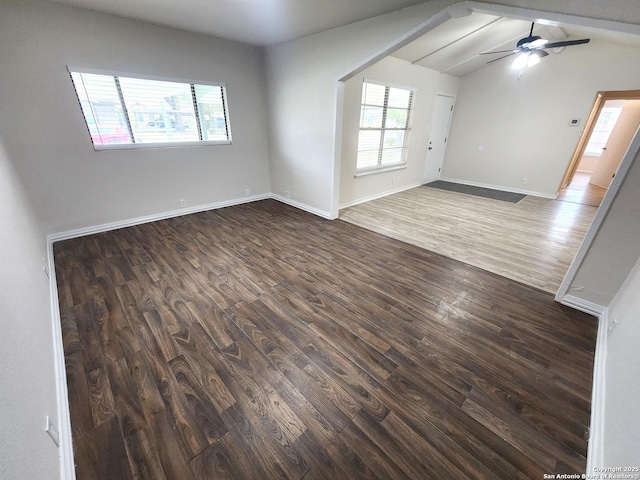 unfurnished room with plenty of natural light, lofted ceiling with beams, a ceiling fan, and dark wood-style flooring