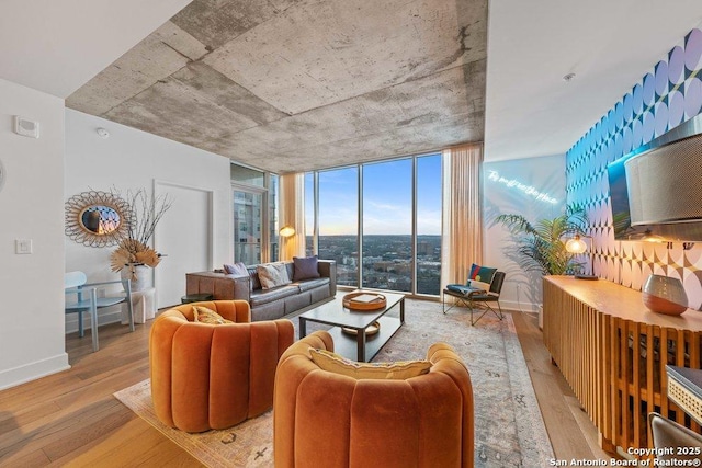 living room with expansive windows, baseboards, and wood finished floors