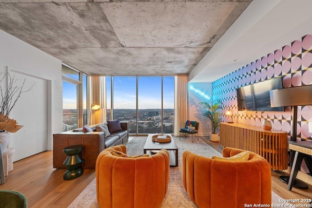 living room featuring a wealth of natural light, a wall of windows, and wood finished floors