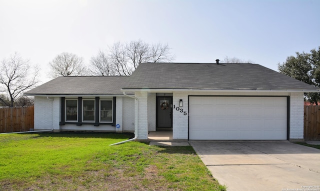 ranch-style house with a front lawn, fence, brick siding, and driveway