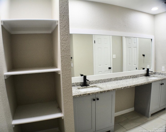 bathroom with a sink, double vanity, and tile patterned floors