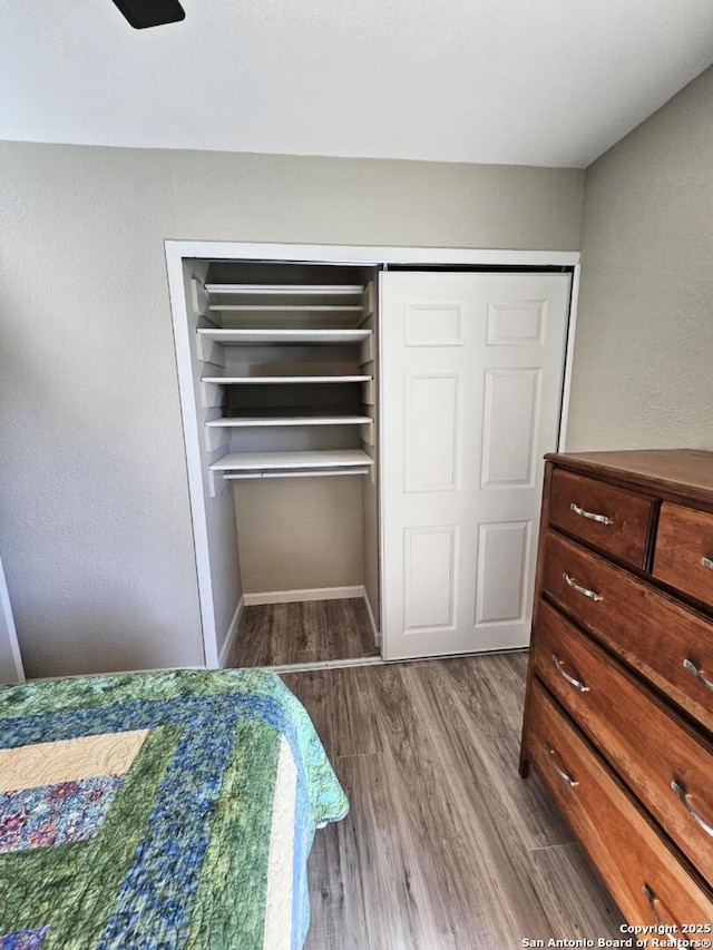 bedroom with baseboards and wood finished floors