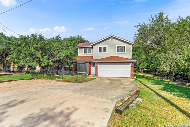 traditional-style home featuring fence, concrete driveway, a front yard, an attached garage, and brick siding