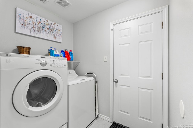 laundry area featuring visible vents, washer and clothes dryer, light tile patterned floors, baseboards, and laundry area