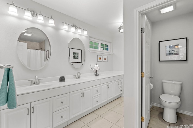 bathroom featuring tile patterned floors, toilet, double vanity, and a sink