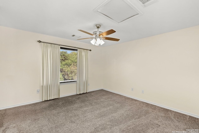 carpeted empty room with visible vents, attic access, and baseboards