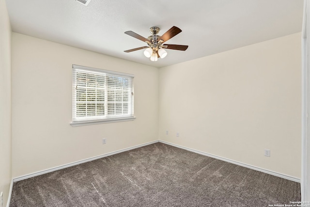 carpeted spare room featuring ceiling fan and baseboards