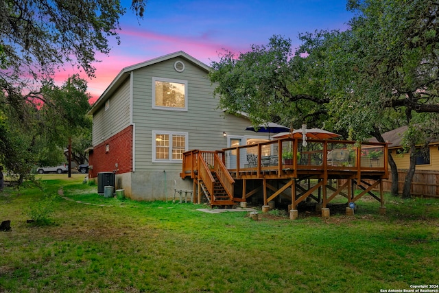 back of property with stairway, fence, a yard, a deck, and central air condition unit